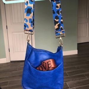 Ah-dorned blue messenger bag with leopard strap blue and gold. Faux leather